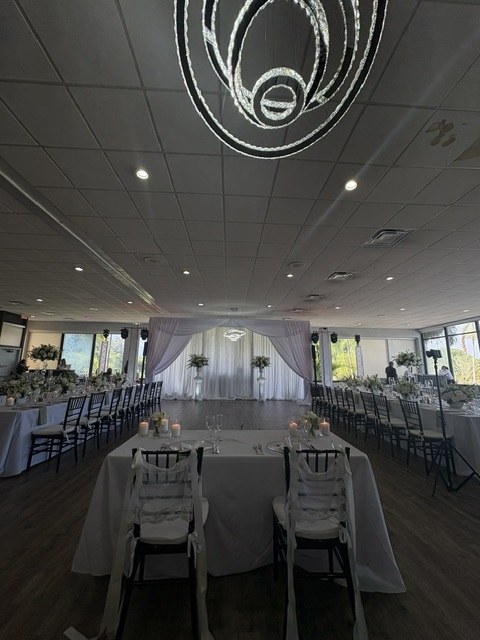 Redland Golf banquet hall set for a wedding with draped backdrop and chandelier