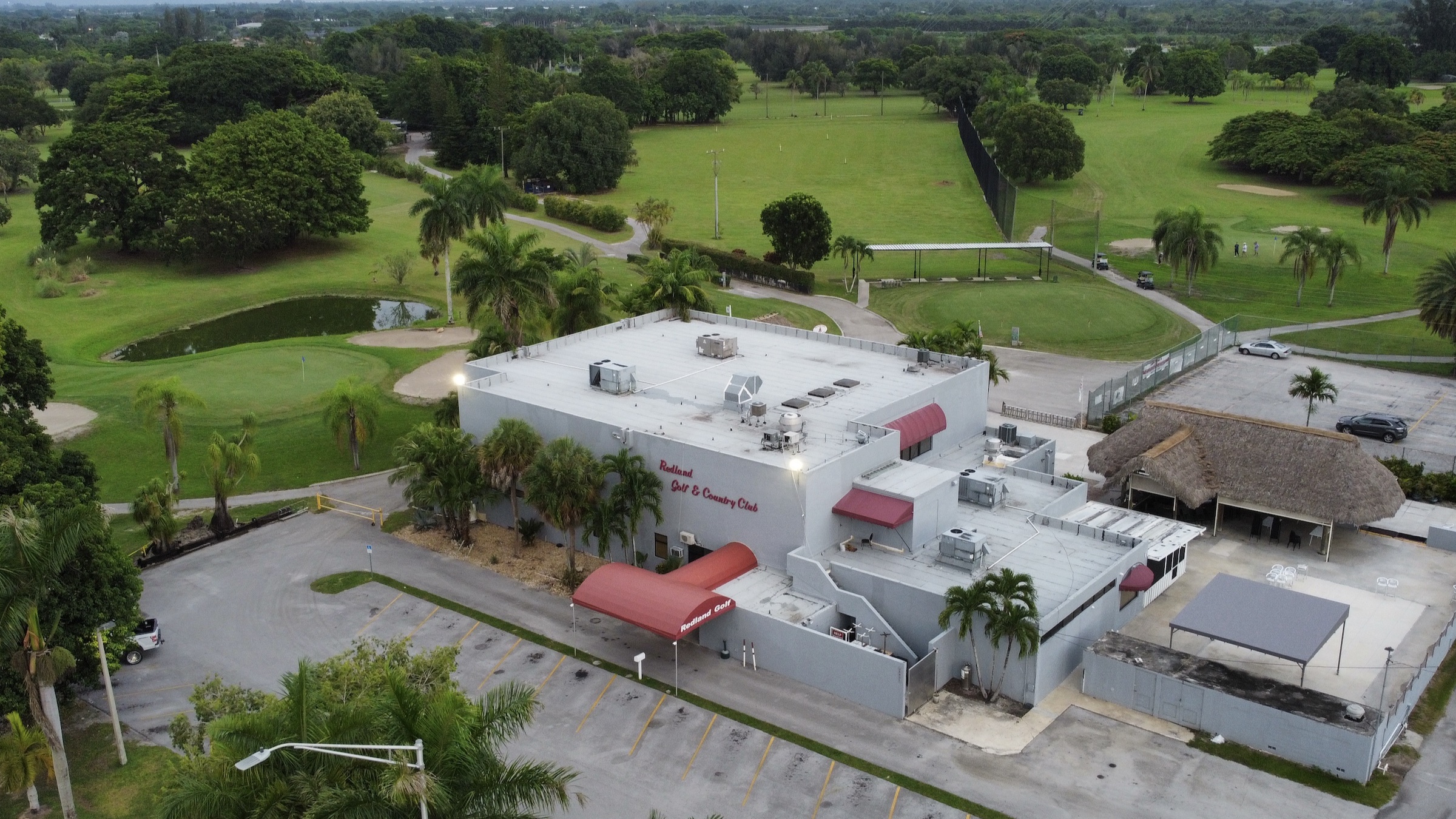 Aerial view of Redland Golf and Country Club, the clubhouse, pond, fairways, and practice range.